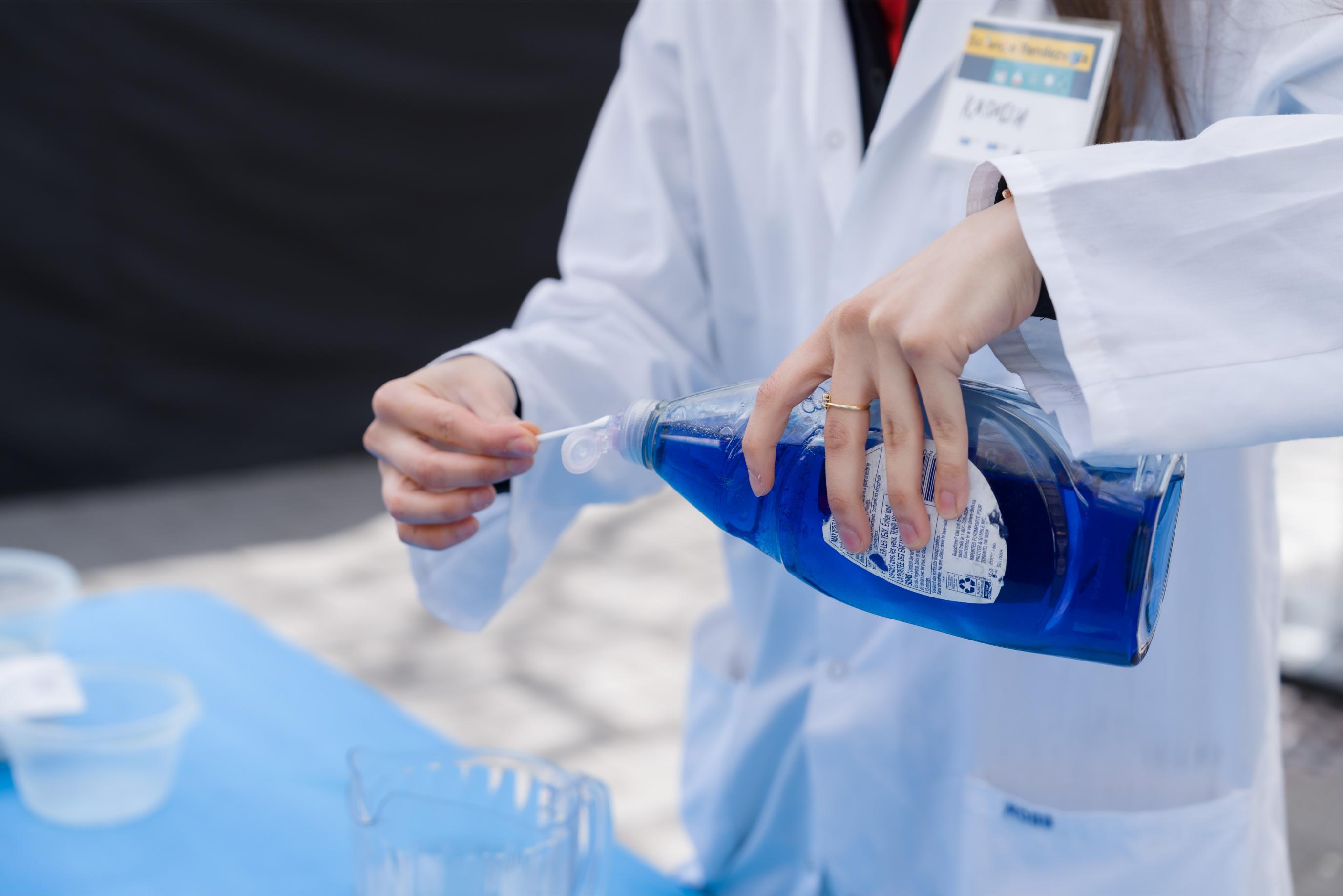 Volunteer using dish soap in a pocket science activity.
